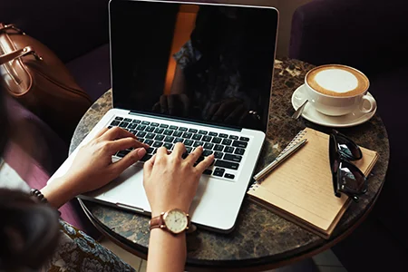 hands-unrecognizable-woman-typing-laptop-cafe